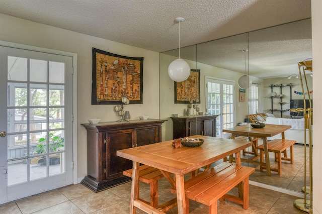 tiled dining space with a healthy amount of sunlight and a textured ceiling