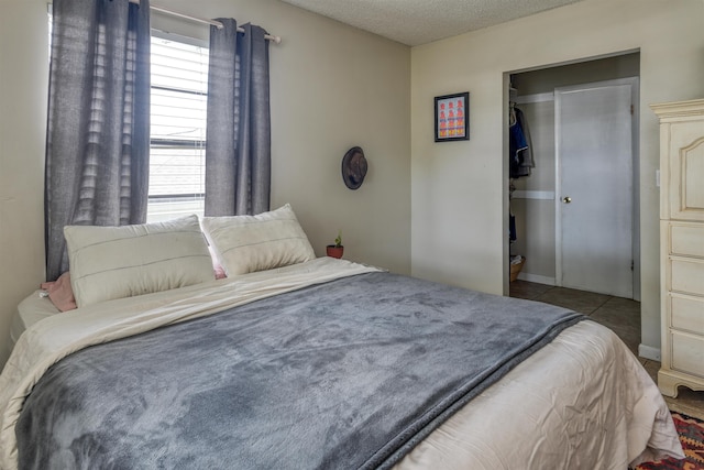 tiled bedroom featuring a closet and a textured ceiling