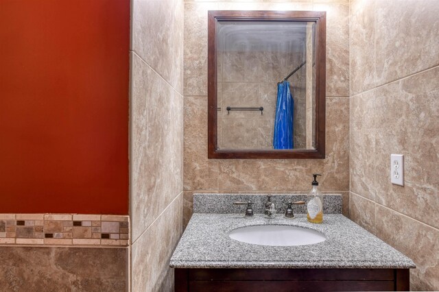 bathroom with vanity and tile walls