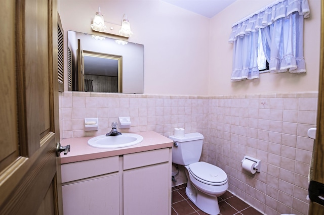 bathroom featuring tile patterned flooring, vanity, tile walls, and toilet