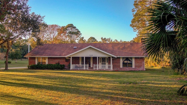 ranch-style home featuring a porch and a front yard