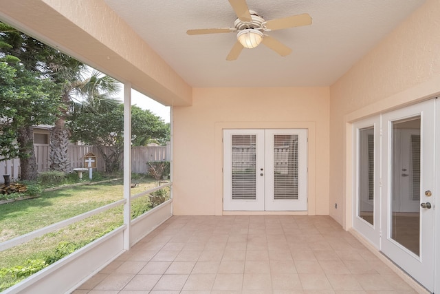 unfurnished sunroom with ceiling fan and french doors