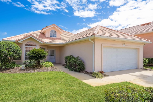 mediterranean / spanish home with a garage and a front lawn