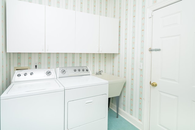 washroom featuring carpet flooring, washer and clothes dryer, and cabinets