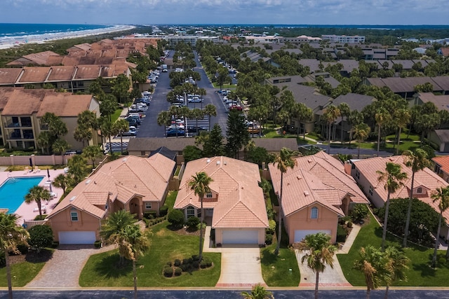 birds eye view of property featuring a water view and a beach view