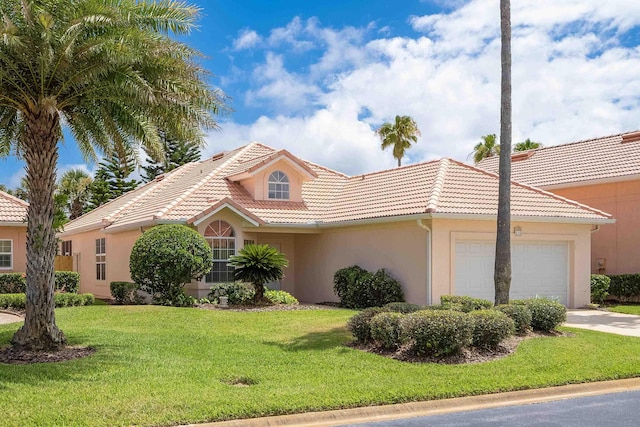 mediterranean / spanish home with a front lawn and a garage