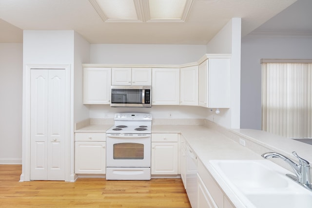 kitchen featuring electric range, sink, white cabinets, and light hardwood / wood-style flooring