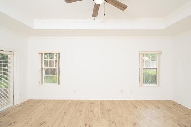 empty room featuring a tray ceiling, light hardwood / wood-style flooring, ceiling fan, and ornamental molding