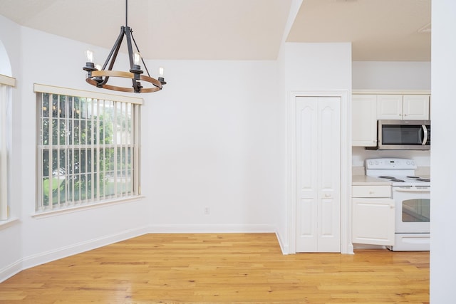 kitchen with white cabinets, decorative light fixtures, light hardwood / wood-style floors, and white electric range