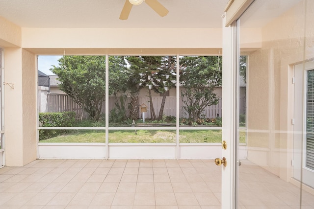 unfurnished sunroom featuring a wealth of natural light and ceiling fan