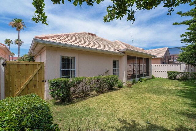 back of property featuring a yard and a sunroom