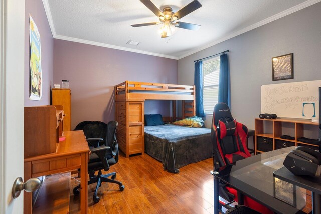 bedroom featuring wood-type flooring, ornamental molding, and ceiling fan