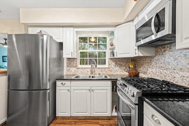 605 A St, Saint Augustine, FL 32080 - kitchen featuring appliances with stainless steel finishes, white cabinets, tasteful backsplash, dark countertops, and wood finished floors