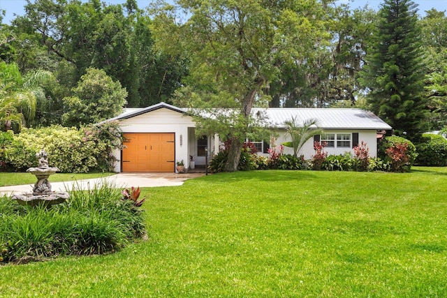 605 A St, Saint Augustine, FL 32080 - ranch-style home featuring driveway, an attached garage, a front yard, stucco siding, and a metal roof