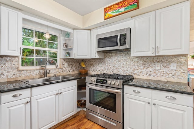 605 A St, Saint Augustine, FL 32080 - kitchen featuring appliances with stainless steel finishes, white cabinetry, light wood-style floors, and decorative backsplash