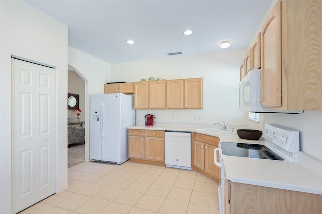 kitchen with light countertops, visible vents, light brown cabinetry, a sink, and white appliances