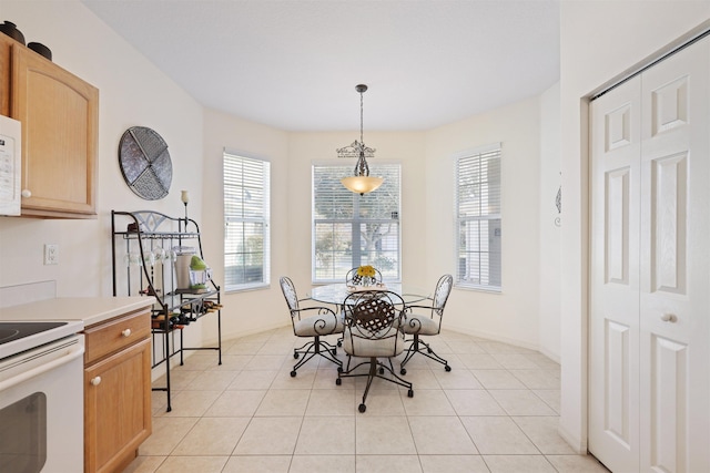 dining space with baseboards and light tile patterned floors