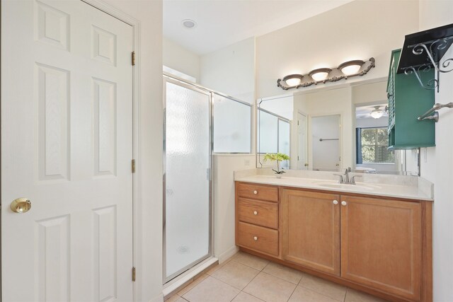 full bathroom with a stall shower, double vanity, a sink, and tile patterned floors