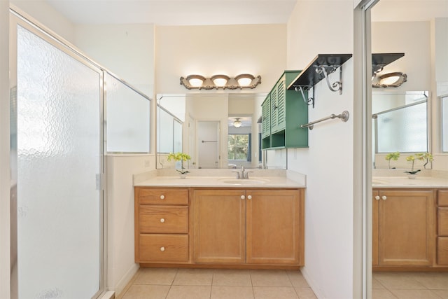 bathroom featuring a stall shower, two vanities, a sink, and tile patterned floors