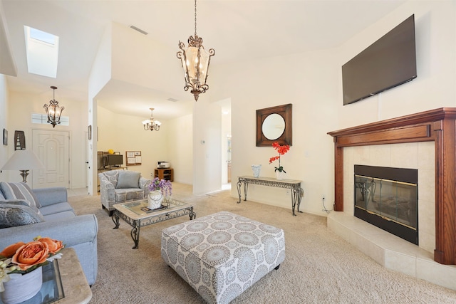 living room featuring carpet, visible vents, a chandelier, and a tiled fireplace