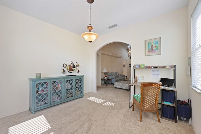 office area featuring arched walkways, carpet floors, plenty of natural light, and visible vents