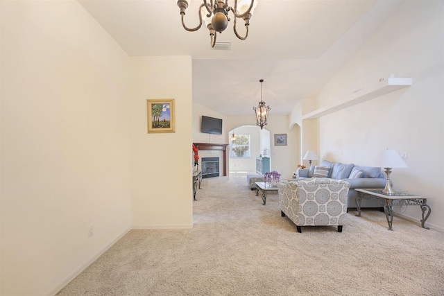 carpeted living room with arched walkways, a glass covered fireplace, a chandelier, and lofted ceiling