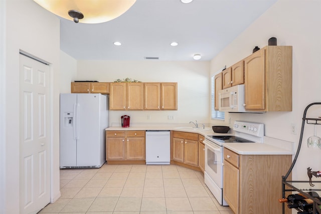 kitchen with light tile patterned floors, light countertops, light brown cabinets, a sink, and white appliances