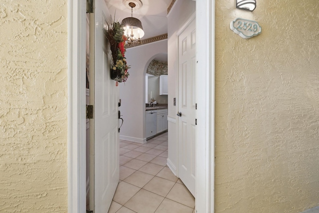 corridor with light tile patterned floors and sink