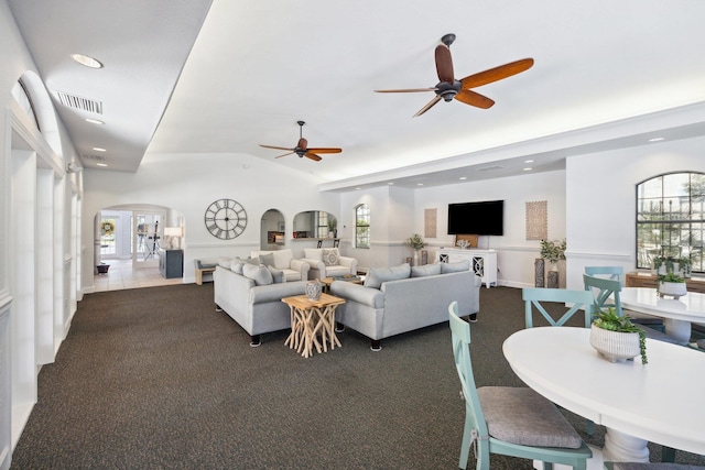 carpeted living room featuring ceiling fan and vaulted ceiling