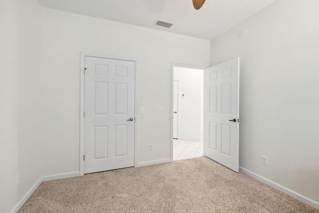 unfurnished bedroom featuring light carpet and ceiling fan