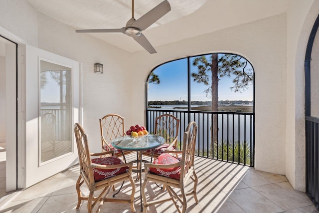 sunroom / solarium featuring a water view and ceiling fan