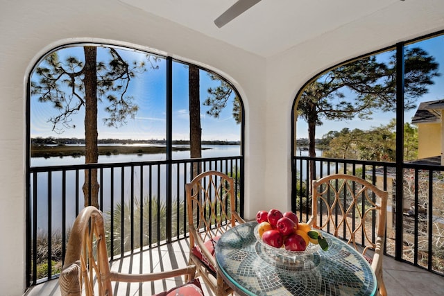 sunroom featuring a water view