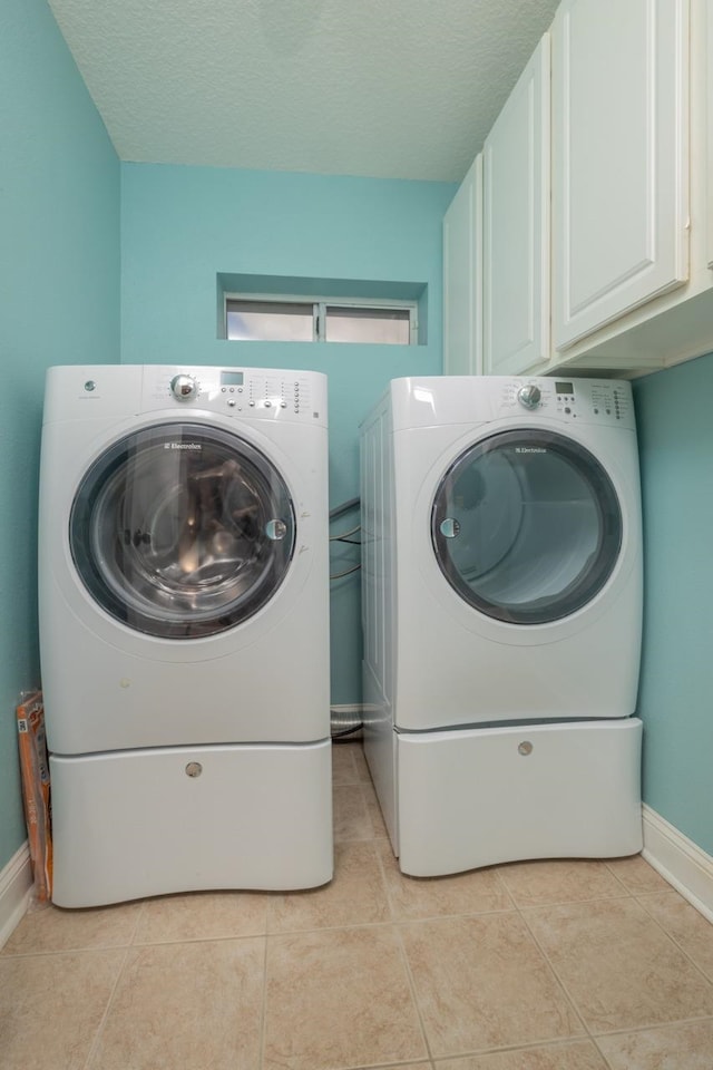 517 Weeping Willow Ln, Saint Augustine, FL 32080 - laundry room with cabinet space, independent washer and dryer, baseboards, light tile patterned flooring, and a textured ceiling