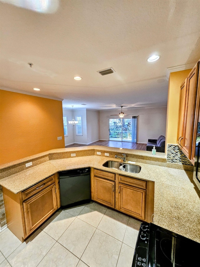 kitchen with black dishwasher, visible vents, stove, brown cabinets, and a sink