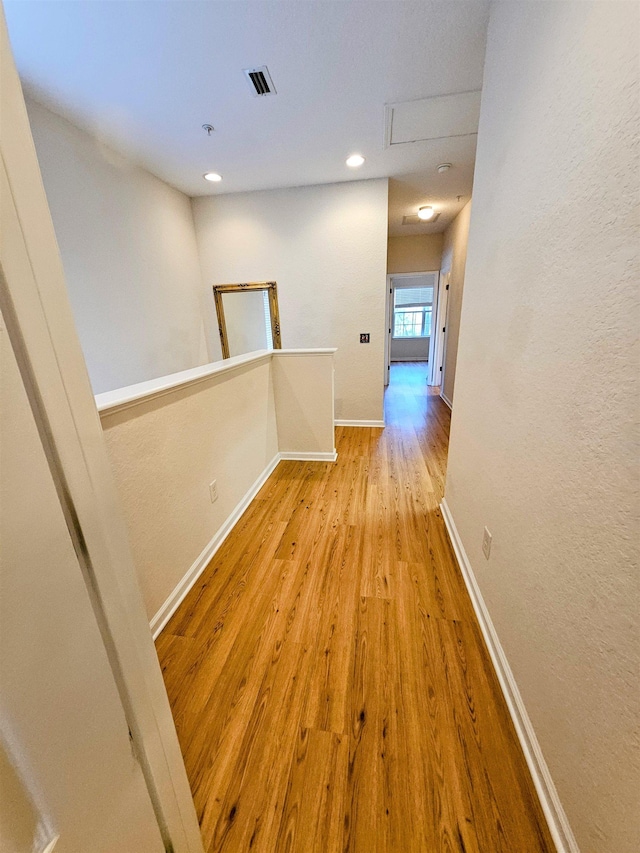 hall with recessed lighting, visible vents, an upstairs landing, wood finished floors, and baseboards