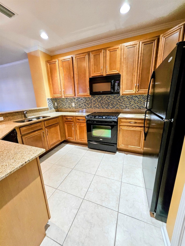 kitchen with light stone counters, ornamental molding, a sink, black appliances, and backsplash