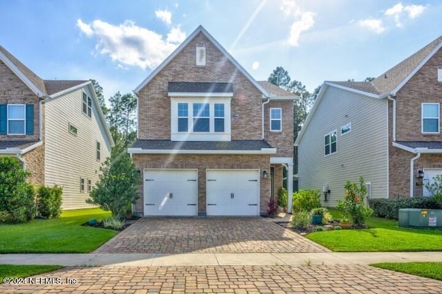 view of front facade with a front lawn, decorative driveway, brick siding, and an attached garage