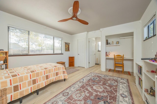 bedroom featuring ceiling fan, ornamental molding, and light wood-style floors