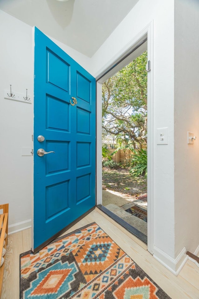 foyer entrance with light wood-style flooring and baseboards