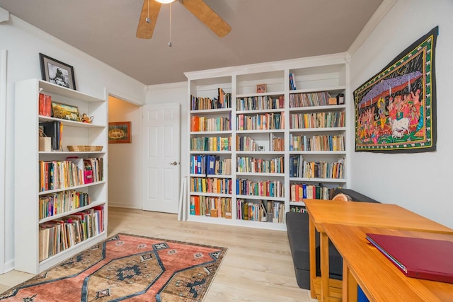 interior space featuring a ceiling fan, ornamental molding, and wood finished floors