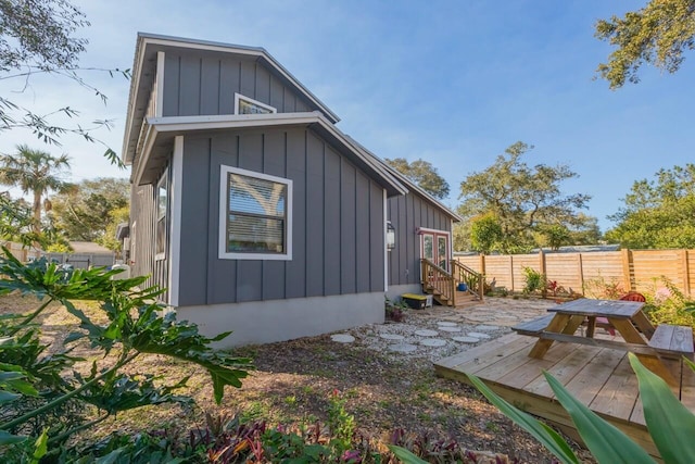 view of property exterior featuring entry steps, board and batten siding, and a fenced backyard