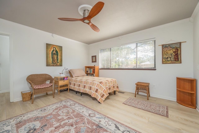 bedroom with a ceiling fan, crown molding, baseboards, and wood finished floors