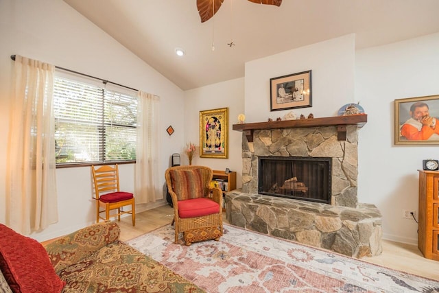 living area with baseboards, a ceiling fan, lofted ceiling, wood finished floors, and a fireplace