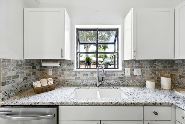 1684 Leon St, Saint Augustine, FL 32080 - kitchen with a sink, dishwasher, white cabinetry, and tasteful backsplash