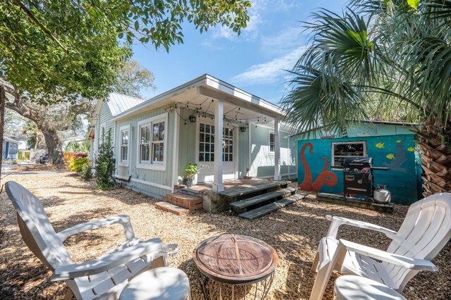 73 Kings Ferry Way, Saint Augustine, FL 32084 - back of property featuring an outdoor structure, a fire pit, french doors, and metal roof