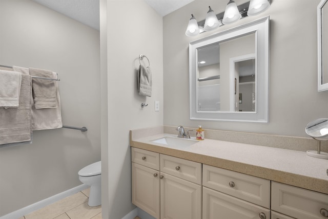 bathroom with toilet, tile patterned floors, baseboards, and vanity