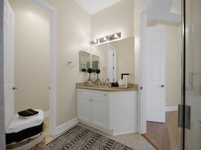 bathroom with vanity, baseboards, and tile patterned floors