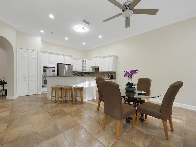 dining space featuring arched walkways, visible vents, baseboards, and recessed lighting