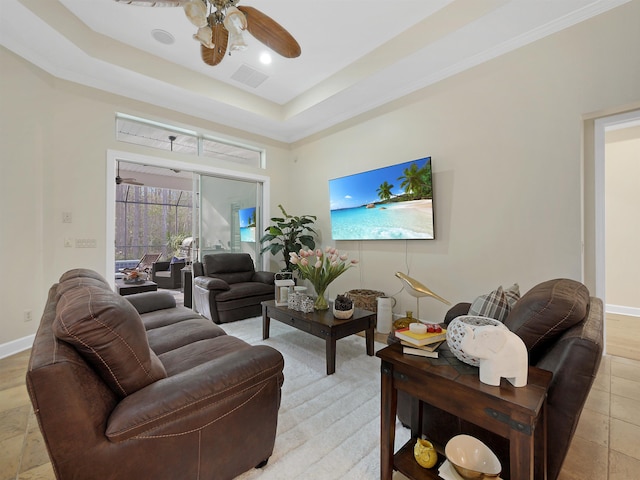 living area featuring a ceiling fan, a raised ceiling, visible vents, and baseboards