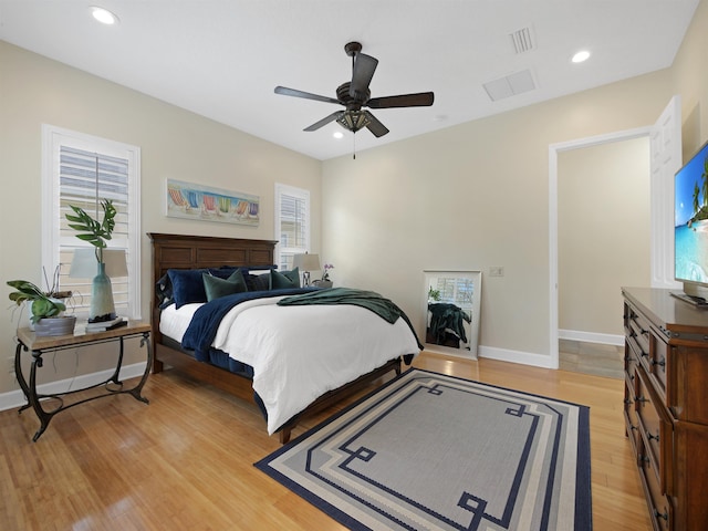 bedroom with light wood-type flooring, multiple windows, baseboards, and recessed lighting